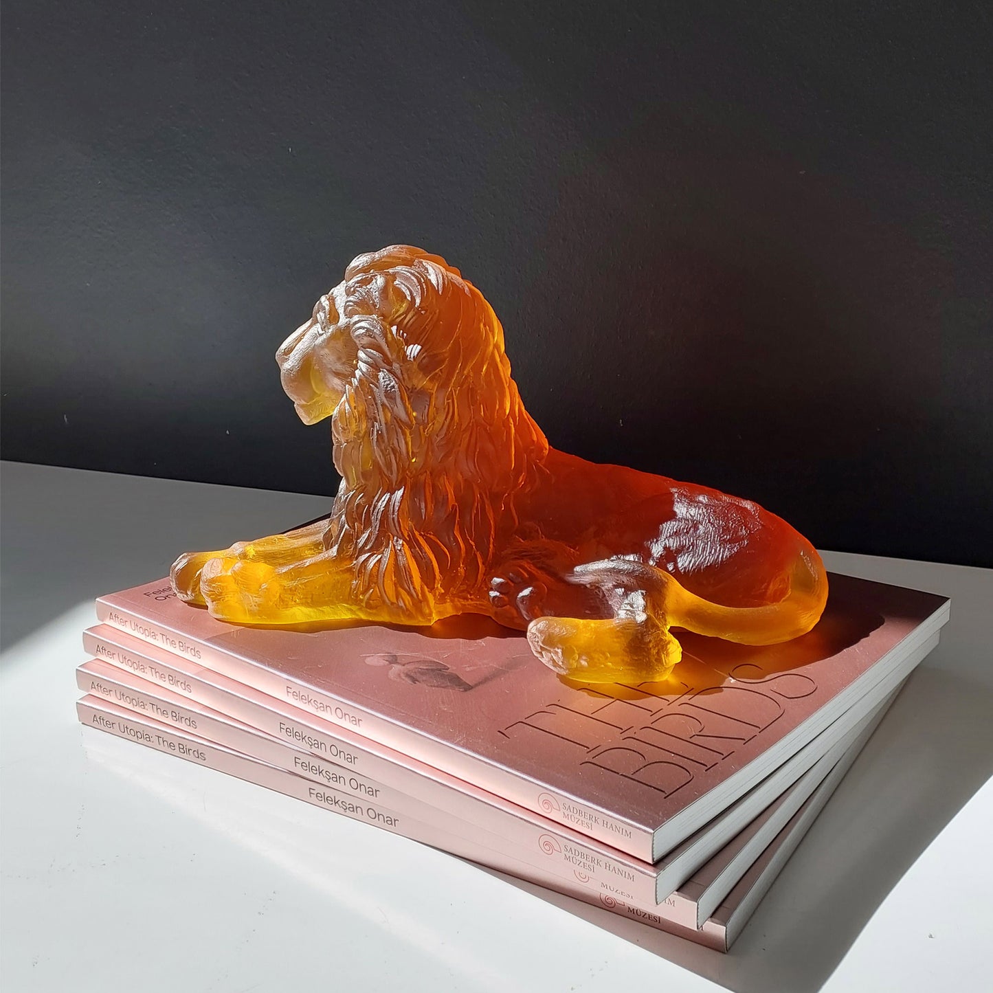 Lion Premium Glass Sculpture Amber on stack of books