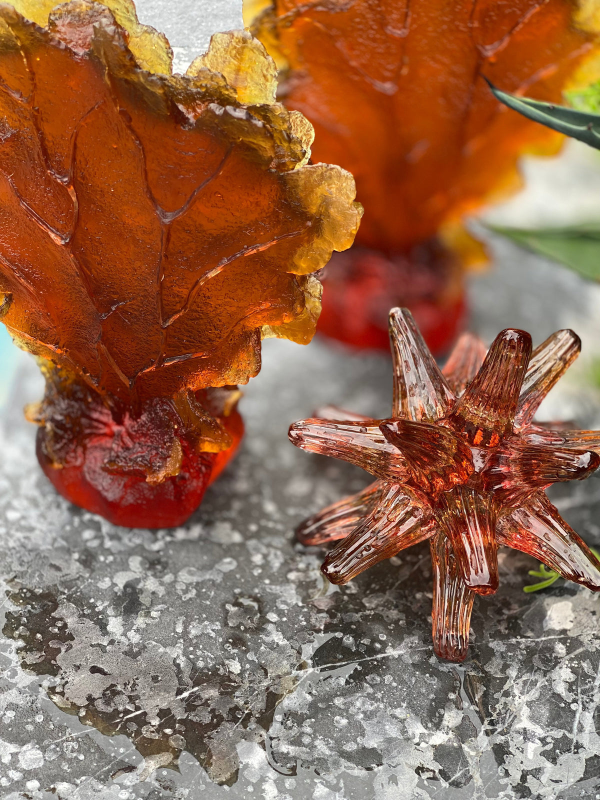 Sea Urchin Glass Sculpture Sunset on marble next to glass coral