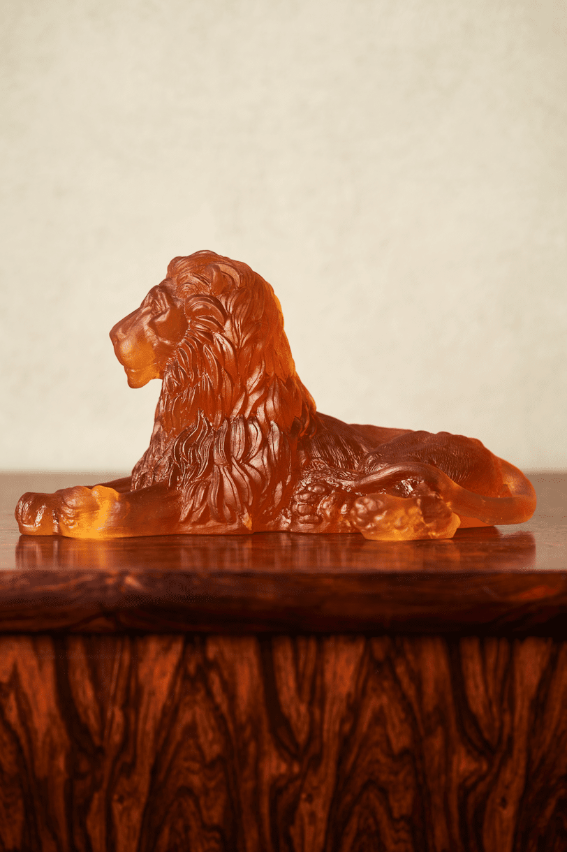 Lion Premium Glass Sculpture Amber on wooden table side view